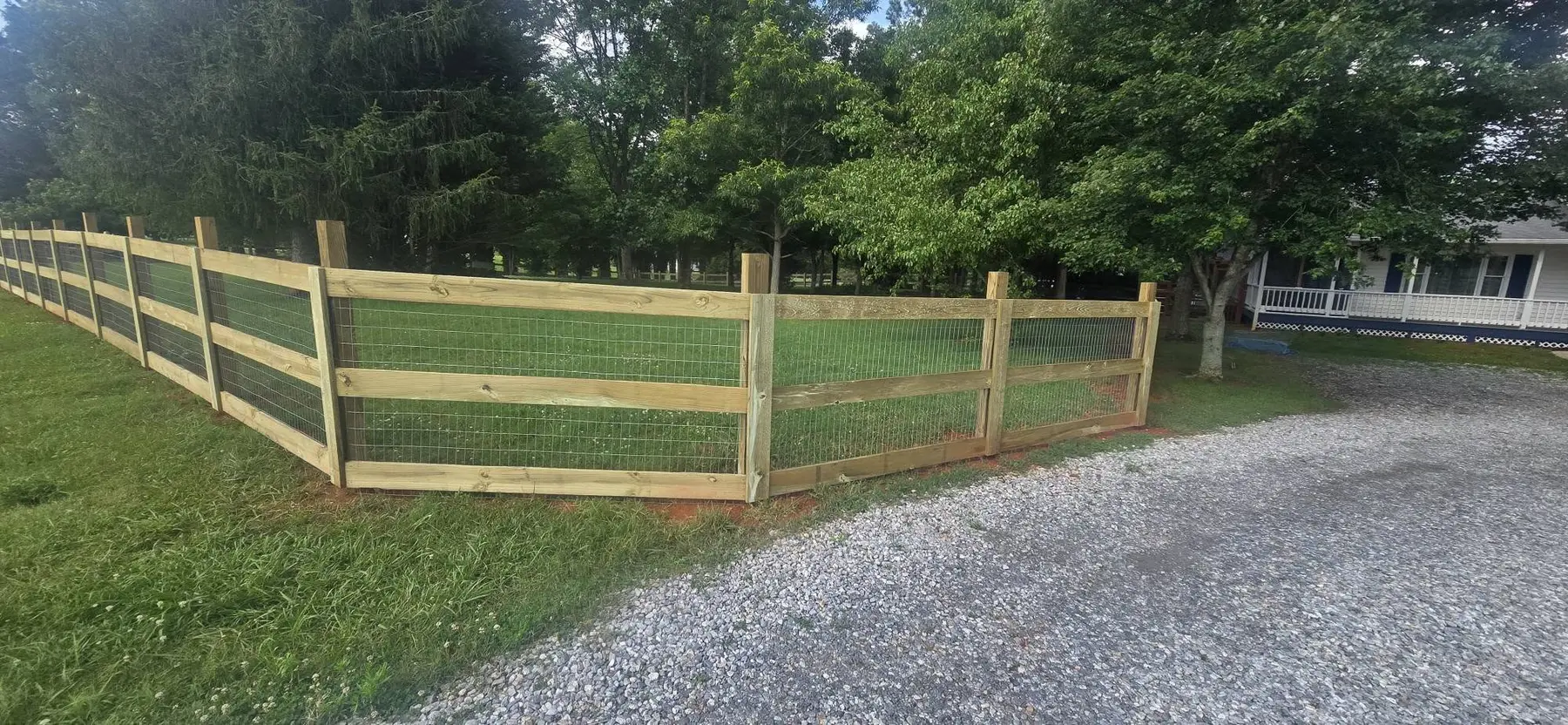 Custom wood gate and wire fence enclosing an outdoor area