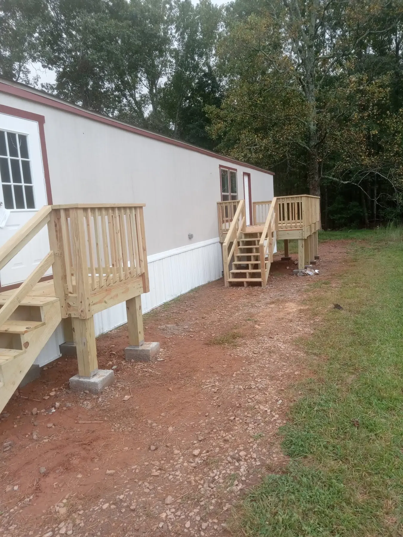 Two completed pressure-treated wood entry decks on a residential home